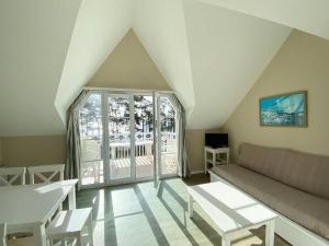 - un salon avec un canapé et une grande fenêtre dans l'établissement Appartement en duplex front de mer, Cap Coz, à Fouesnant