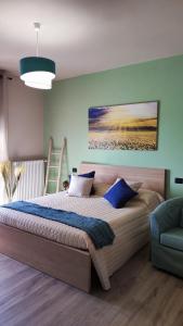 a bedroom with a large bed with a painting on the wall at Tania's Home Langhe in Feisoglio