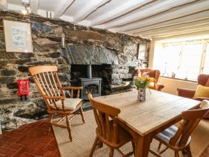 a room with a wooden table and chairs and a fireplace at 2 Bwth Mawr in Barmouth