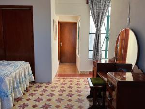 1 dormitorio con cama, tocador y espejo en Hotel Casa del Zocalo, en Tlatlauquitepec