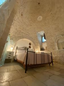 ein Schlafzimmer mit einem Bett in einer Steinmauer in der Unterkunft Trulli Occhi Di Pietra in Alberobello