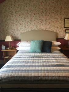 um quarto com uma cama com almofadas em Regency House em Walton-on-the-Naze