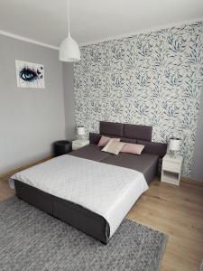 ein Schlafzimmer mit einem großen Bett und einer Wand in der Unterkunft Apartament z widokiem na jezioro Ukiel in Olsztyn