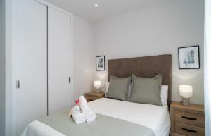 ein Schlafzimmer mit einem Bett mit zwei Handtüchern darauf in der Unterkunft AAC Málaga - Apartamento muy cómodo y bien comunicado, a 1,3km del centro in Málaga