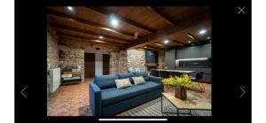 sala de estar con sofá azul y cocina en CAN VOLAN, en Sant Pere Despuig