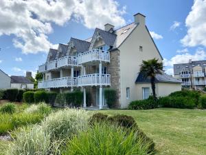 a large white house with balconies on a lawn at Appartement en duplex front de mer, Cap Coz in Fouesnant