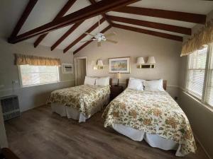 a bedroom with two beds and a ceiling fan at Midway Motel & Cottages in Eastham