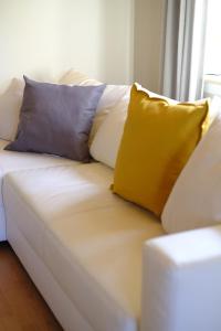Un sofá blanco con tres almohadas. en Ferienhaus am Hainberg en Colditz