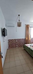 a room with a bed and a television in it at Star Sianna Village Rooms to let in Siána