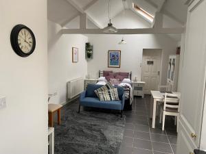 a living room with a bed and a clock on the wall at Jollys of Goodrich in Goodrich