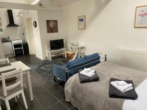 a bedroom with a blue bed and a living room at Jollys of Goodrich in Goodrich