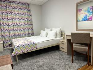 um quarto com uma cama, uma secretária e uma cadeira em мини-отель Arctic Hotel em Murmansk