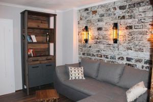a living room with a couch and a brick wall at Appartement Altstadt, Gasthaus Hirsch in Hirschhorn