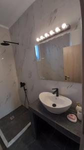 ein Bad mit einem Waschbecken und einem Spiegel in der Unterkunft Sparta Filoxenia House in Xirokámbion