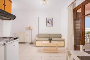 cocina y sala de estar con sofá en Captain Michalis Apartments, en Galatás