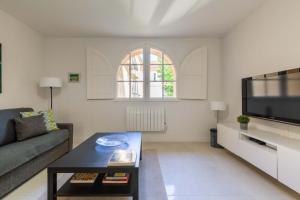 a living room with a couch and a flat screen tv at Appartement cathédrale au calme in Aix-en-Provence