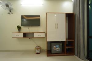a living room with a tv and a cabinet at HOẰNG MINH HOTEL in Sầm Sơn