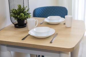 a wooden table with two plates and utensils on it at Lagūna - Šventoji in Šventoji