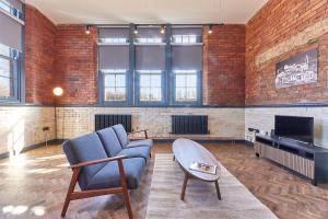 a living room with a blue couch and a tv at No 3 at Simpson Street Apartments Sunderland in Sunderland