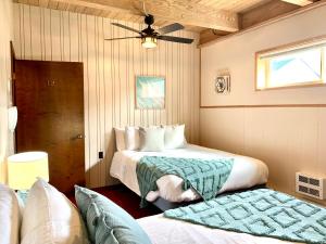 a bedroom with two beds and a ceiling at Breakers Boutique Inn in Westport