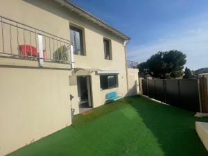 um quintal com um relvado verde em frente a uma casa em Charmant deux pièces dans maison em Roquebrune-Cap-Martin