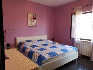 a bedroom with a bed with purple walls and a window at Apartment Poesia in Poreč