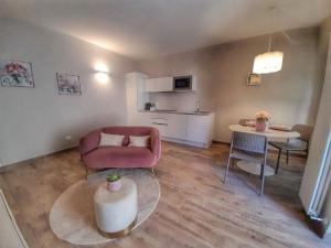 a living room with a pink couch and a table at Alessia Home in Cannobio