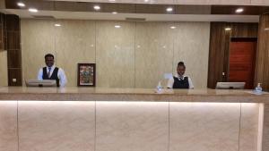 two men sitting at a counter in a hotel lobby at El Doria Hotel in Lomé