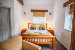 Home Farm & Lodge في بوتري: غرفة نوم بسرير خشبي مع وسادتين