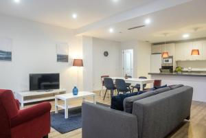 ein Wohnzimmer mit einem Sofa und einem Tisch in der Unterkunft Brand New Apartment With Super Comfortable Beds in Valencia