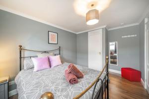 a bedroom with a bed with pink pillows at Dalmarnock Stay in Glasgow