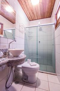 uma casa de banho com um chuveiro, um WC e um lavatório. em Baía Sul Hotel em Barra Grande
