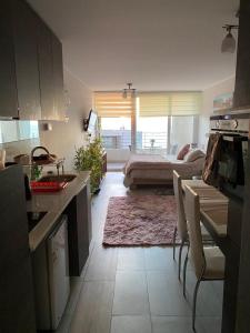 a kitchen and living room with a bed in the background at Depto. estudio con vista al mar in Viña del Mar