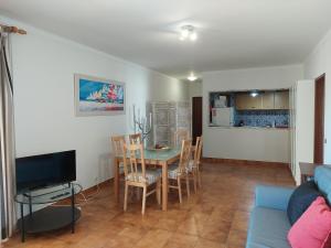 ein Wohnzimmer mit einem Tisch, Stühlen und einem Sofa in der Unterkunft Alltravel Atlântico apartment in Portimão