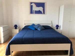 Schlafzimmer mit einem Bett mit blauer Decke in der Unterkunft Bluoltremare in Realmonte