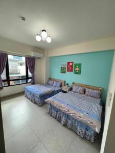 twee bedden in een kamer met blauwe muren bij Lo-ReMi Homestay in Ruisui