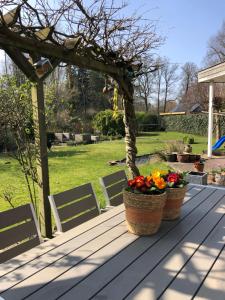 a picnic table with two baskets of flowers on it at Woning tussen bos en water in Dalfsen