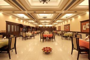 a dining room with tables and chairs in a restaurant at Taj Mahal Hotel Abids in Hyderabad