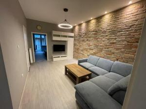 ein Wohnzimmer mit Sofa und Ziegelwand in der Unterkunft Basilica Apartments in Budapest