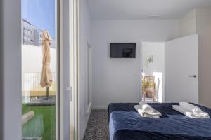 sypialnia z niebieskim łóżkiem i białymi poduszkami w obiekcie Gorgeous Apt with a Large Private Terrace w Walencji