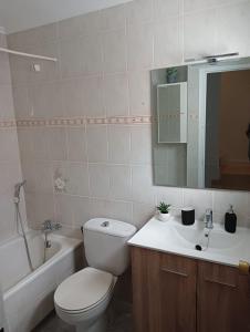 a bathroom with a toilet and a sink and a tub at Apartamento Casa Quiles 