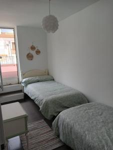 um quarto com 2 camas individuais e uma janela em Apartamento Casa Quiles 