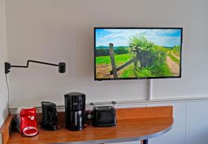 a flat screen tv hanging on a wall above a table at Bergblick471 in Hahnenklee-Bockswiese