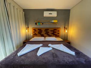 a bedroom with a bed with two towels on it at Pousada Villa Dos Sonhos in Itacaré