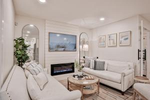 a living room with white furniture and a fireplace at Sunrise Beach Retreat in Flagler Beach