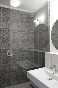 a bathroom with a sink and a shower with a mirror at Szkíta Panzió in Balatonmáriafürdő