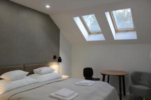 a bedroom with a bed with two white towels on it at Szkíta Panzió in Balatonmáriafürdő