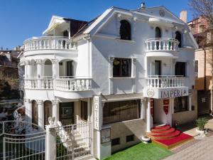 Un grand bâtiment blanc avec balcon est disponible. dans l'établissement Hotel IMPERIA, à Varna