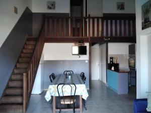 a dining room with a table and a staircase at Strada di a cuma in Vico
