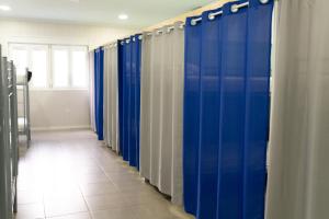 eine Reihe blauer Duschstände in einem Zimmer in der Unterkunft Albergue Barullo - Cubículos - Literas - Habitaciones in Sarria